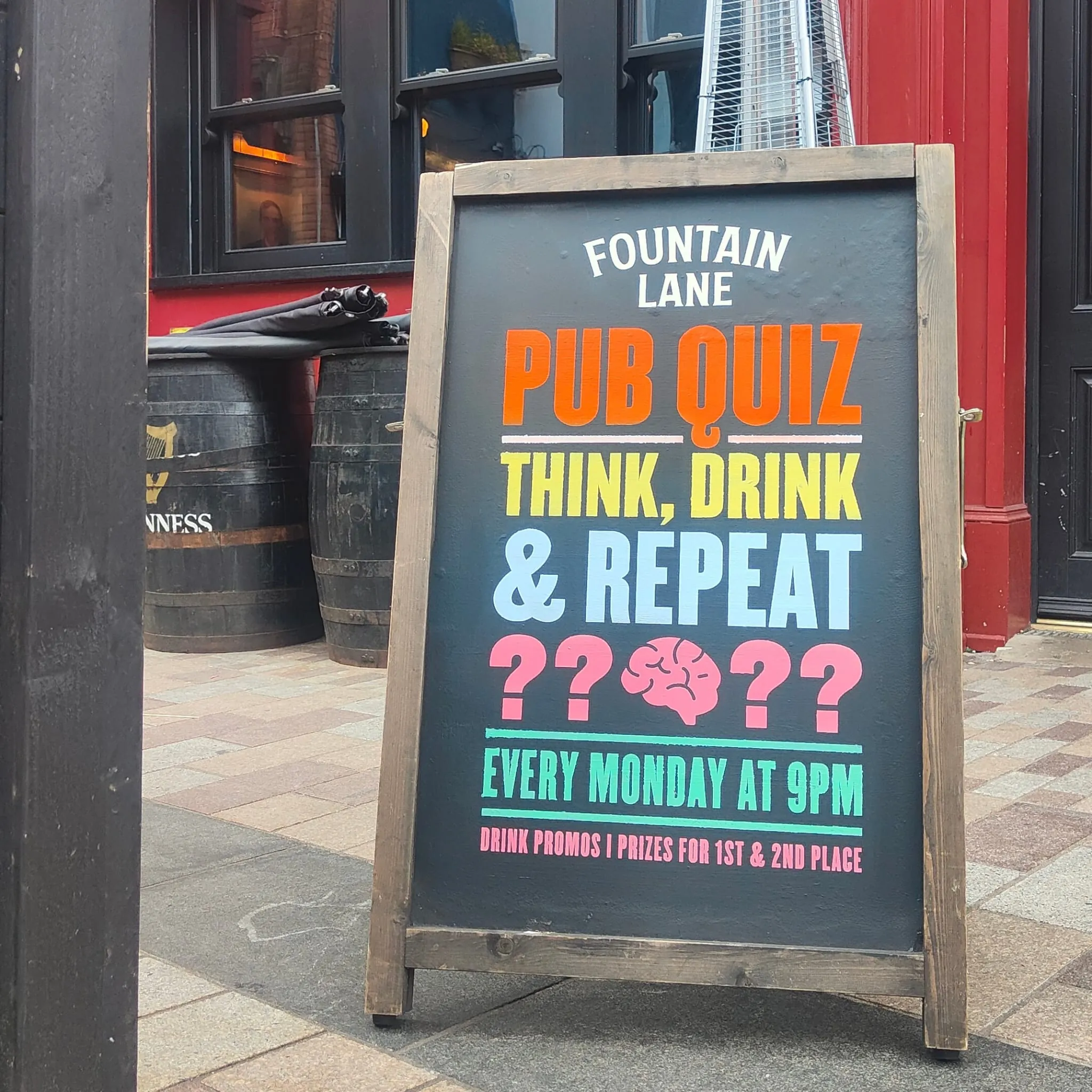 An A-board outside Fountain Lane advertising its Monday pub quiz, with “Think, drink & repeat” in multicoloured lettering and a painted brain.