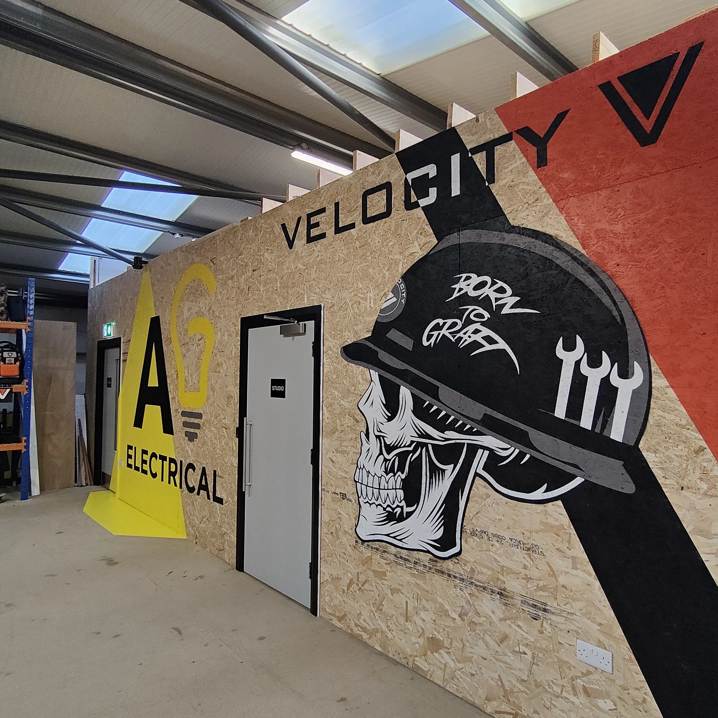 The AG Electrical and Velocity walls finished side by side across the workshop.